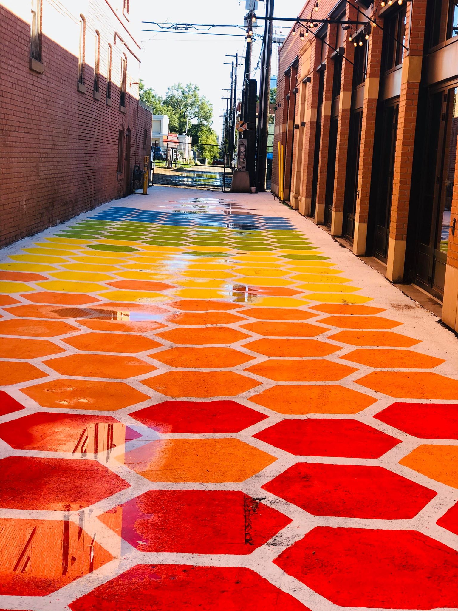 Hexagons in colours of the rainbow stretch down an alley