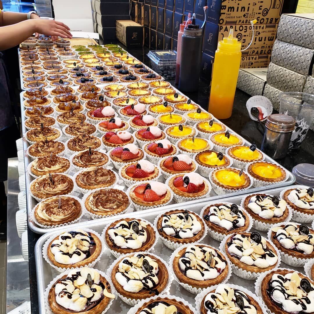 Colourful and decorated mini-tarts stretch out across a long counter