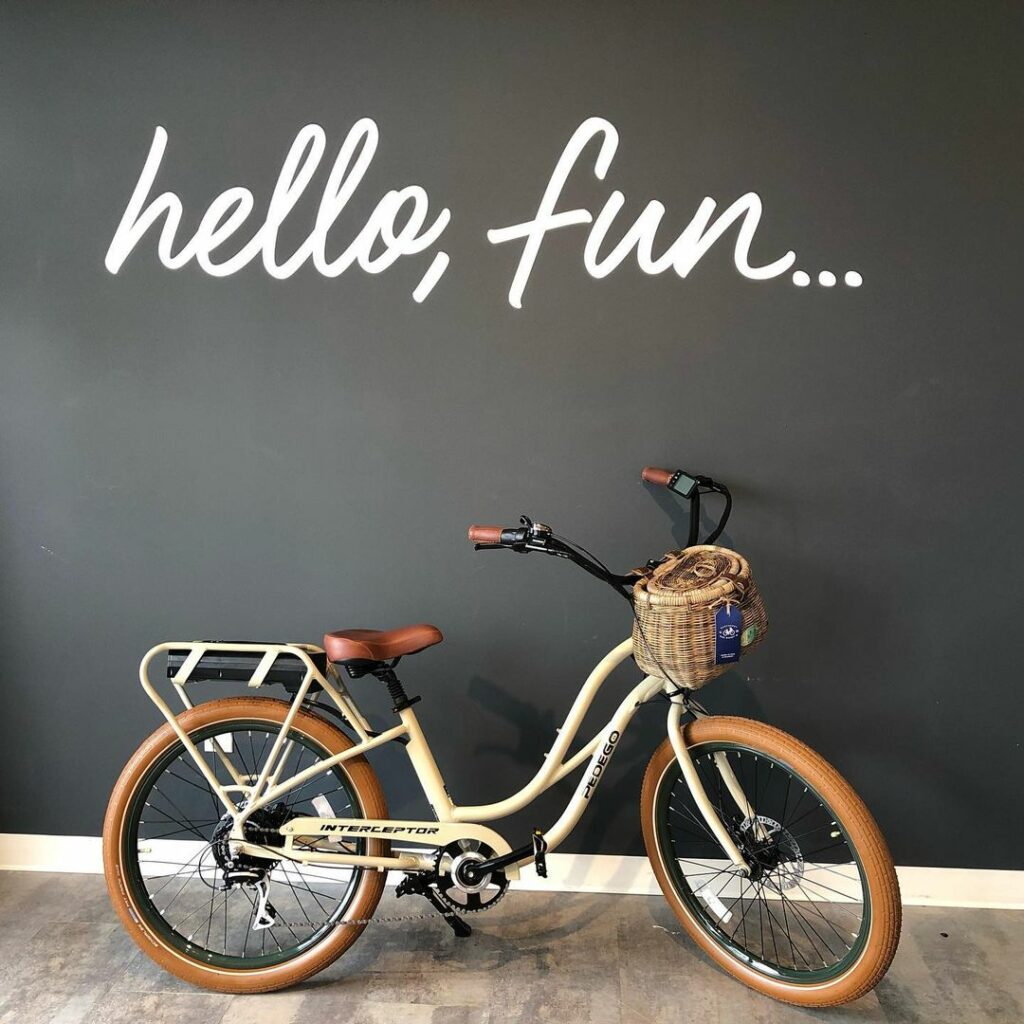 A cruiser-style e-bike sits under a sign that reads "Hello fun"