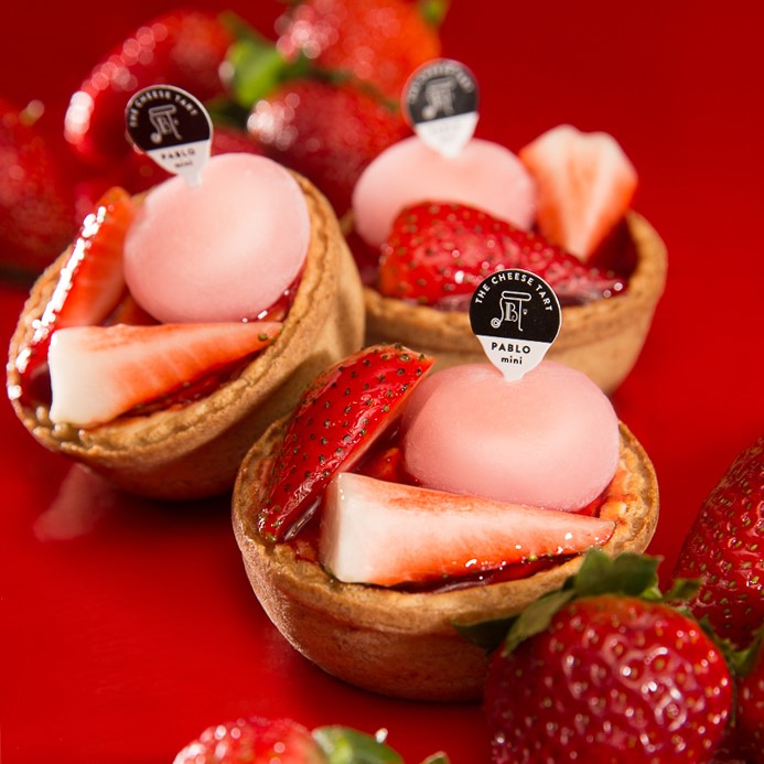 Small tarts are topped with fresh strawberries and pink daifuku, which look like rounded marshmallows