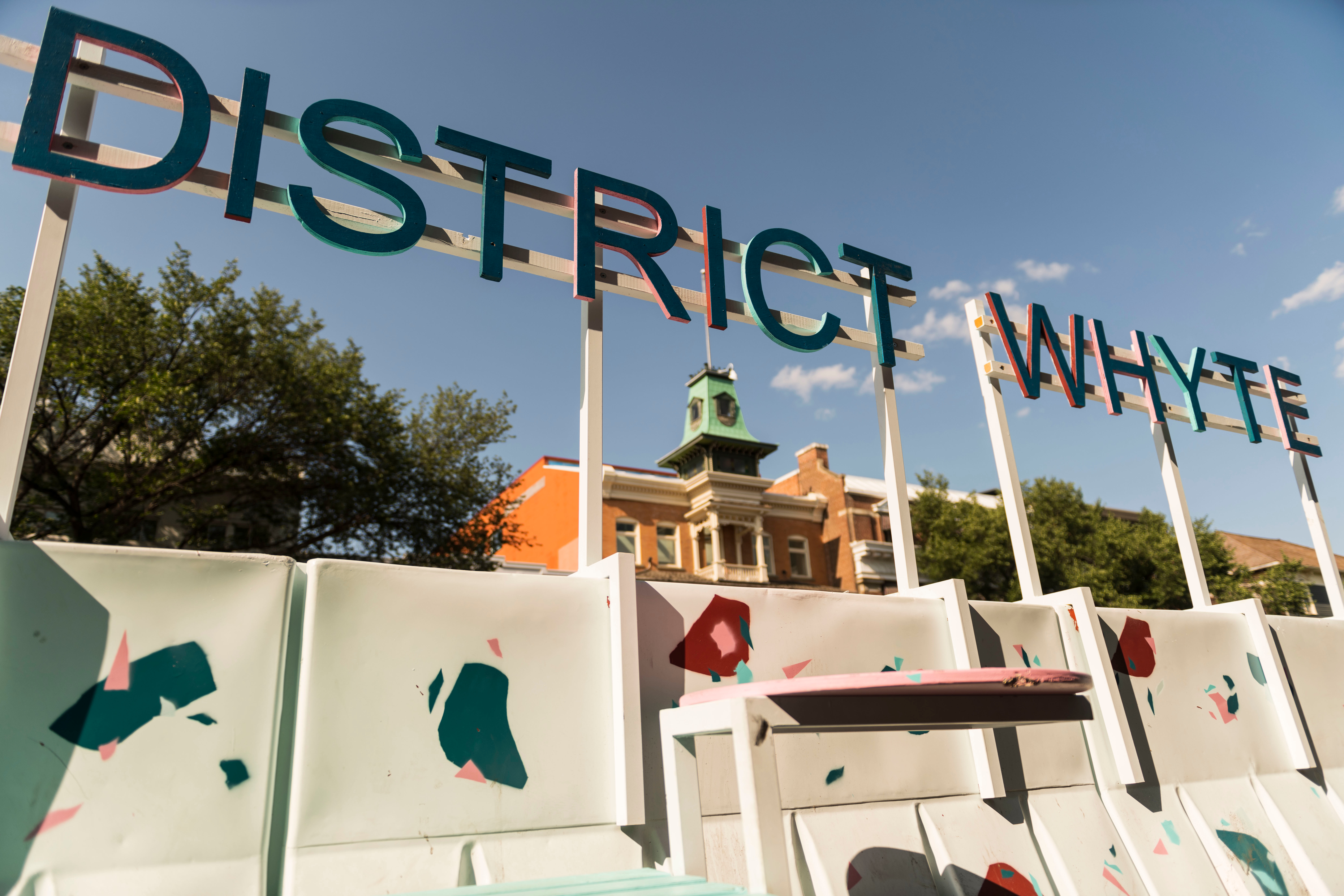 White water barriers splashed with colourful terrazzo blotches with lettering that reads District Whyte